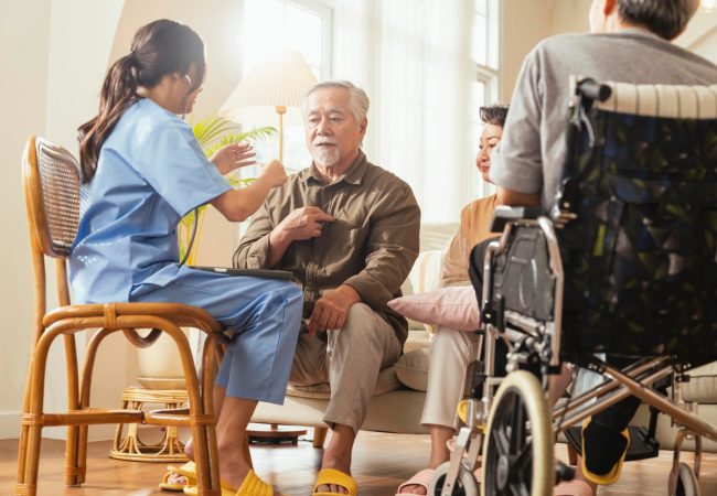 happiness-cheerful-elderly-woman-men-talking-with-female-caregiver-nurse-doctor-having-health-checking-consult-living-areacaretakers-with-senior-couple-sitting-living-room-nursing-home